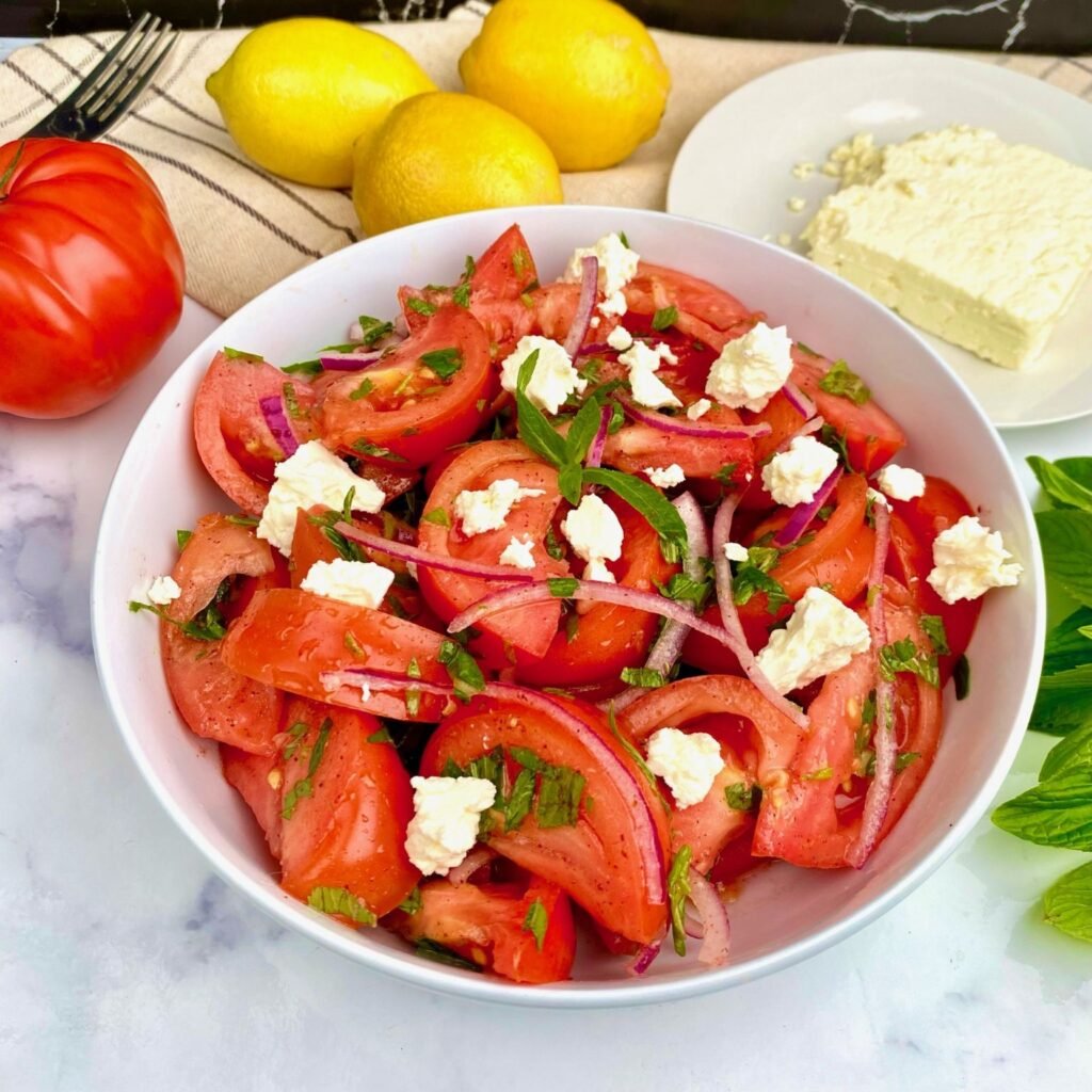 Finishing Heirloom Tomato Salad with Feta